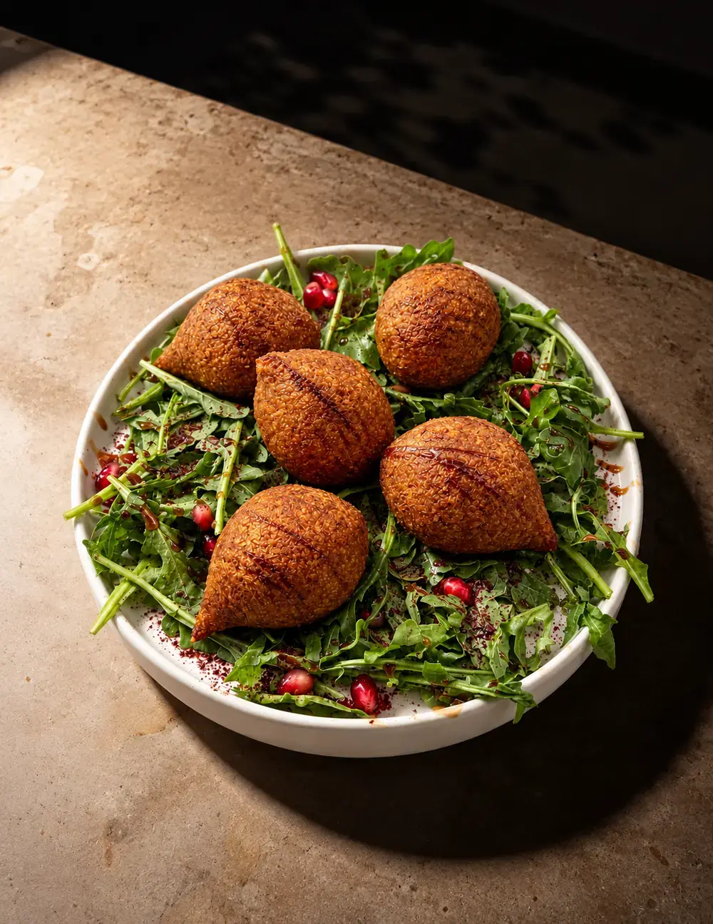 Fried kebbeh on a bed of rocket and pomegranate